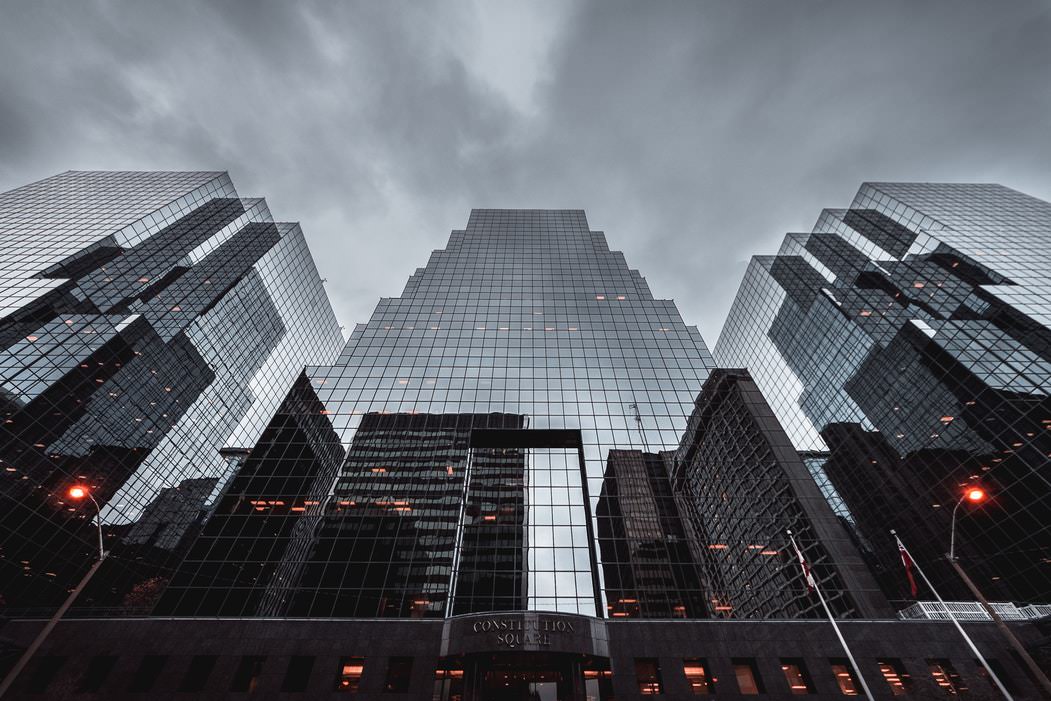 architectural photography of three impressive, tall buildings looking up from the ground